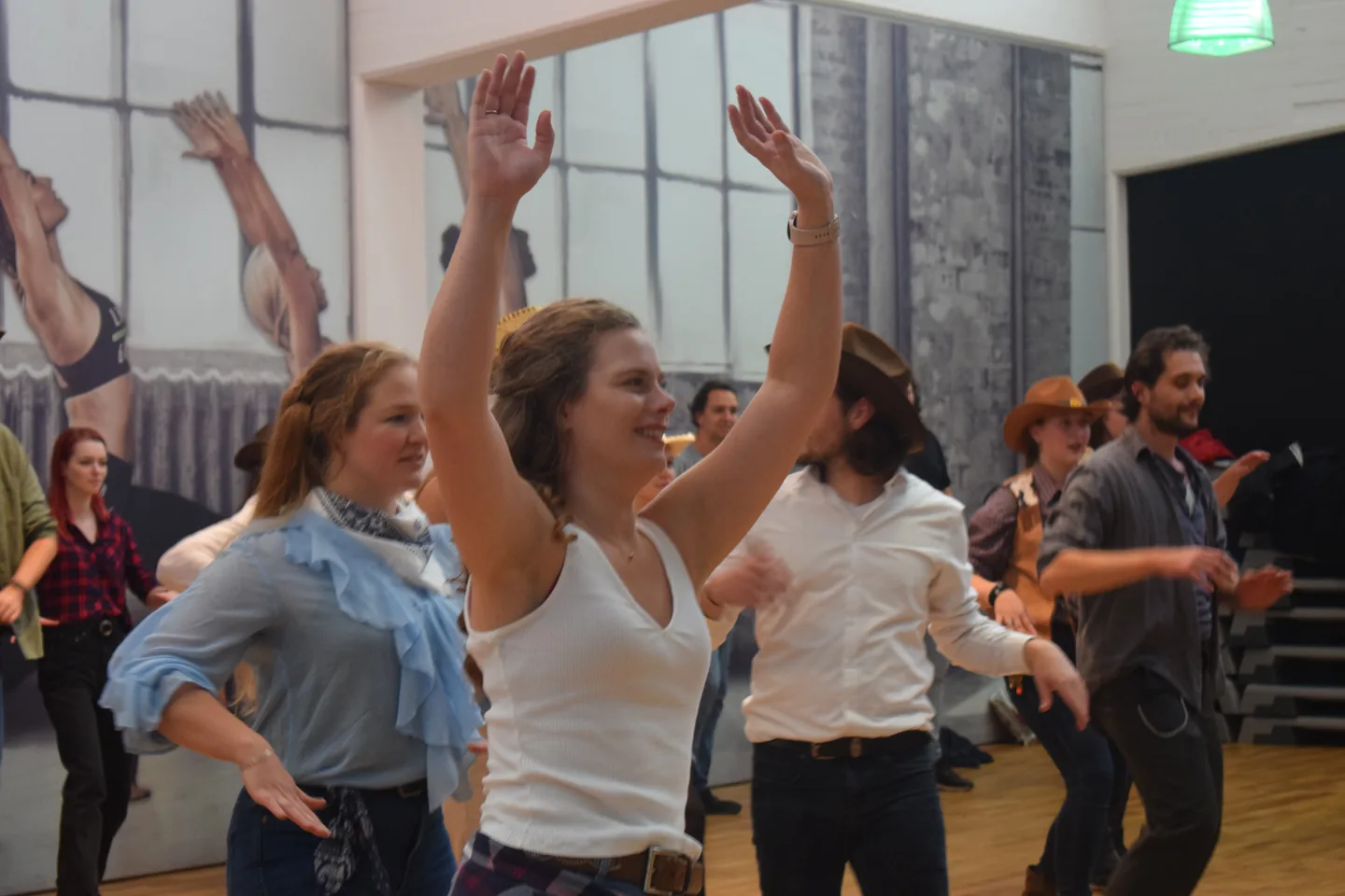 Leden steken hun handen op tijdens het dansen